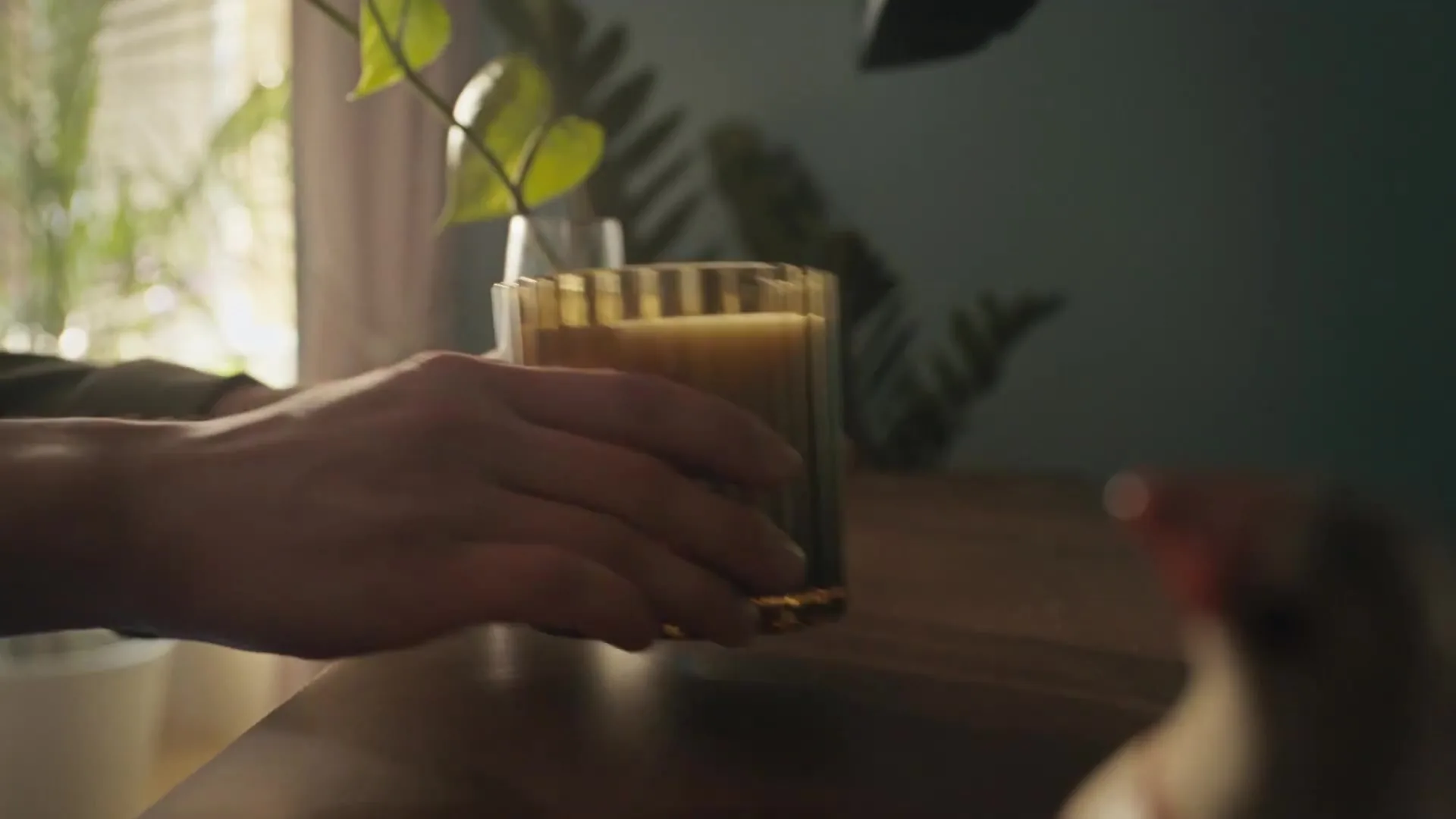 Primer plano de una mano que sostiene un vaso durante una escena del anuncio de IKEA.