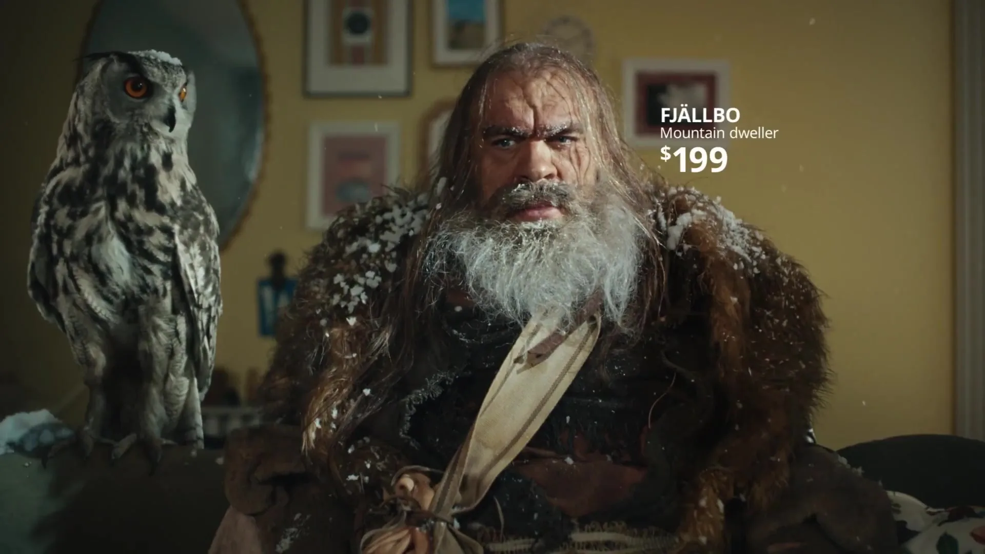 Un personaje de montaña sentado en el salón del anuncio FJÄLLBO.